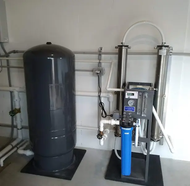 image 5 A water softener and tank in the middle of a room.